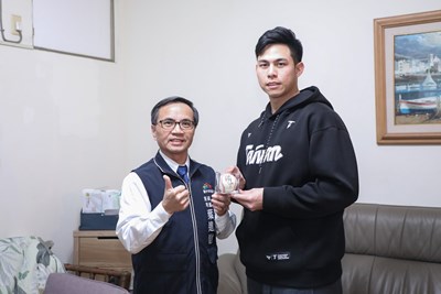 台中捷運公司副總經理葉進財代表盧秀燕市長致贈中華隊投手陳冠偉(右)終身榮譽卡及小綠綠抱枕