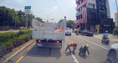 清潔隊員在車陣中撿拾民眾掉落之千元大鈔-1