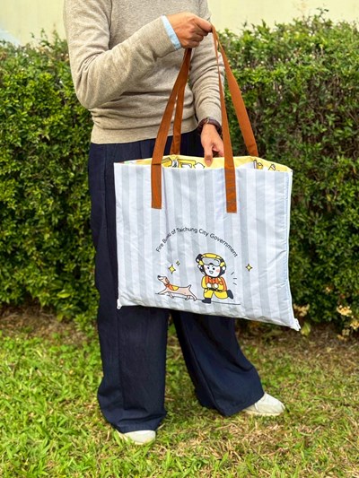 多功能防災提袋印製有消防人員與搜救犬的Q版圖案。