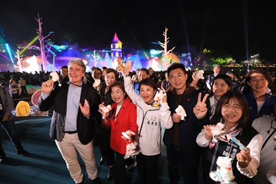 眾人手拿姆明吊飾合影，現場氣氛熱絡