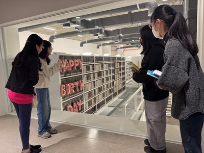 圖書館於密集書庫運用書本巧思排列，在書架間擺出「HBD」（Happy Birthday縮寫）字樣