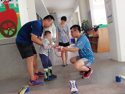 北屯國小適應體育教練及主任協助多障兒童訓練下肢力量及手部抓握動作