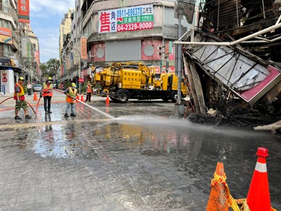 環保局調度灑水車清洗街道上的塵土及灰燼，完成周圍整體清潔